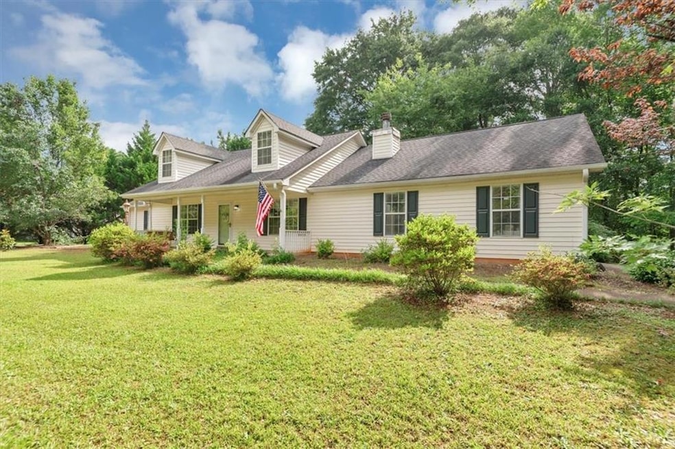 Cape cod-style house with a front yard and a chimney