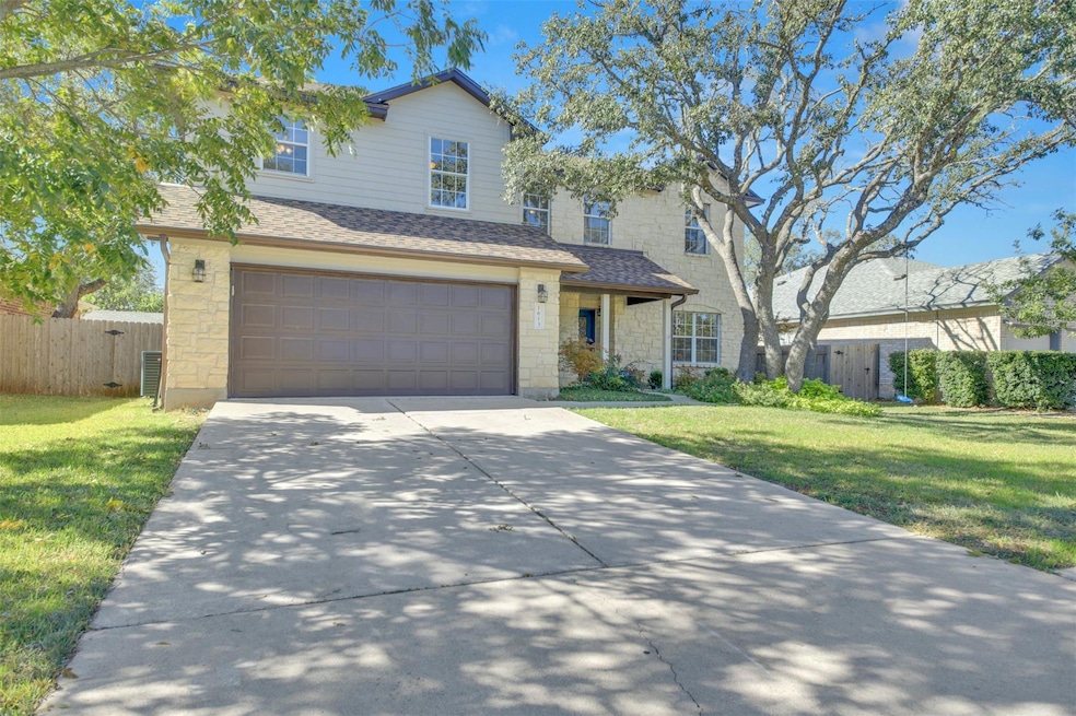 Traditional home featuring stone siding, a shingled roof, concrete driveway, and an attached garage