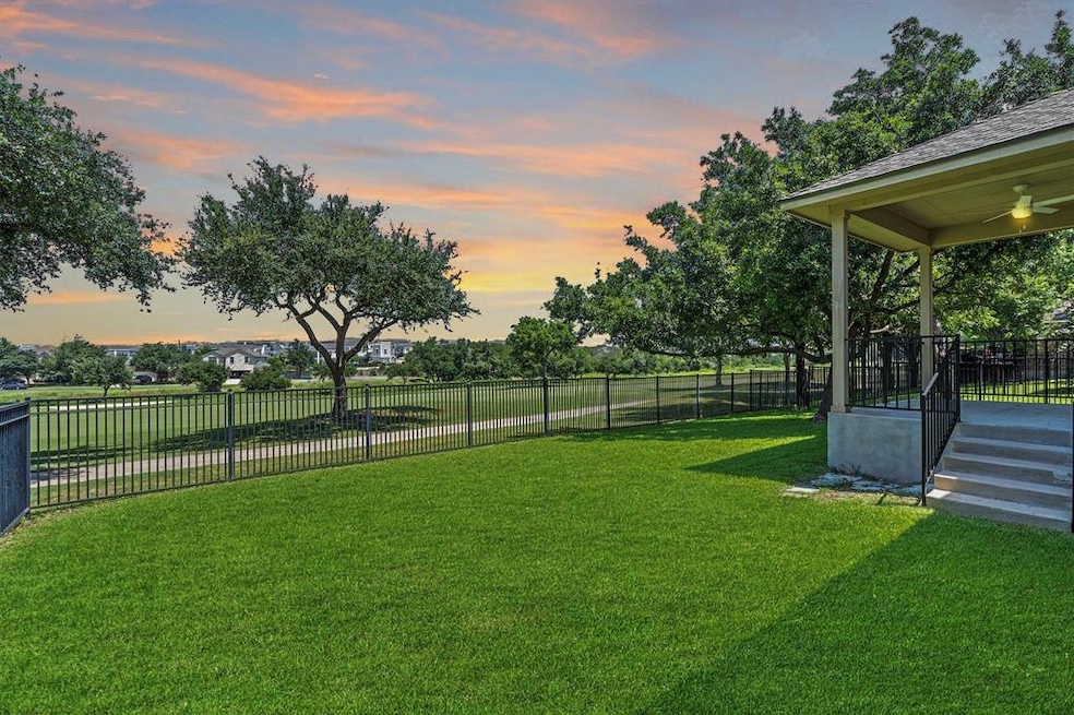 View of yard featuring a ceiling fan and fence