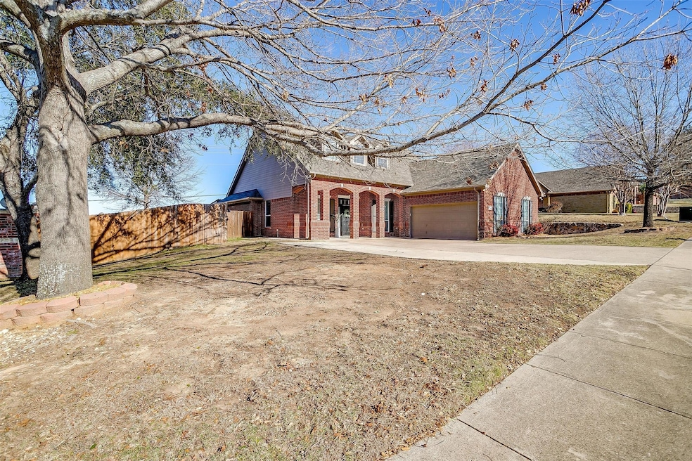 View of front facade with brick siding, driveway, an attached garage, and roof with shingles