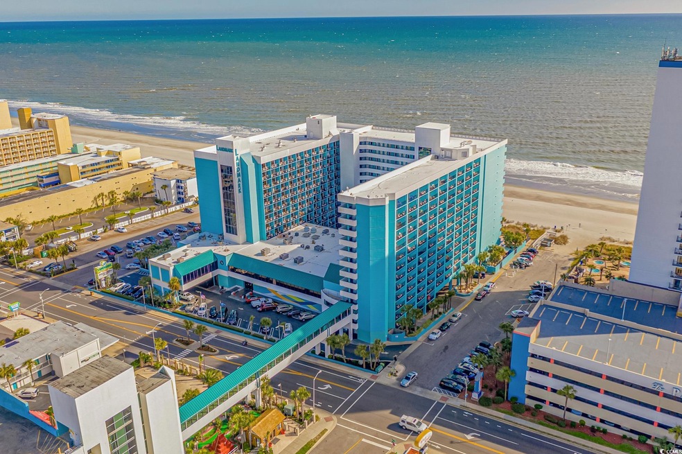 Birds eye view of property featuring a water view and a view of the beach