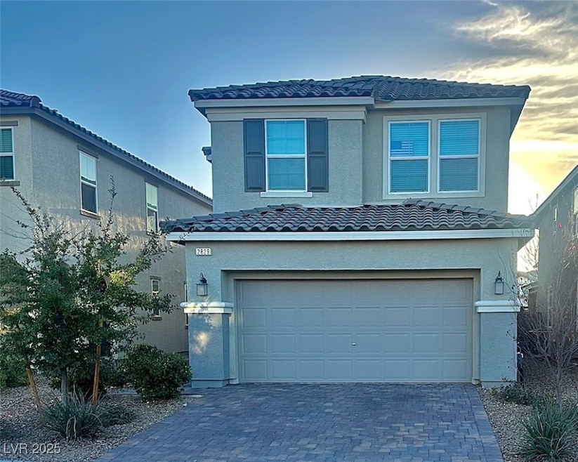 Traditional-style home with decorative driveway, a