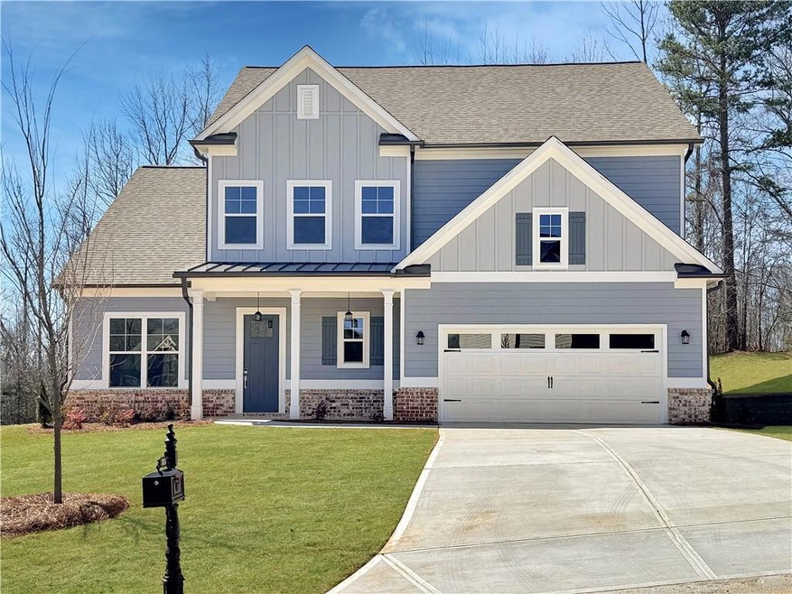 Craftsman-style home featuring a front yard, a gar