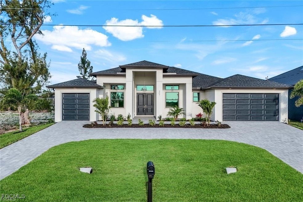 Prairie-style home featuring a front lawn, stucco siding, decorative driveway, roof with shingles, and a garage