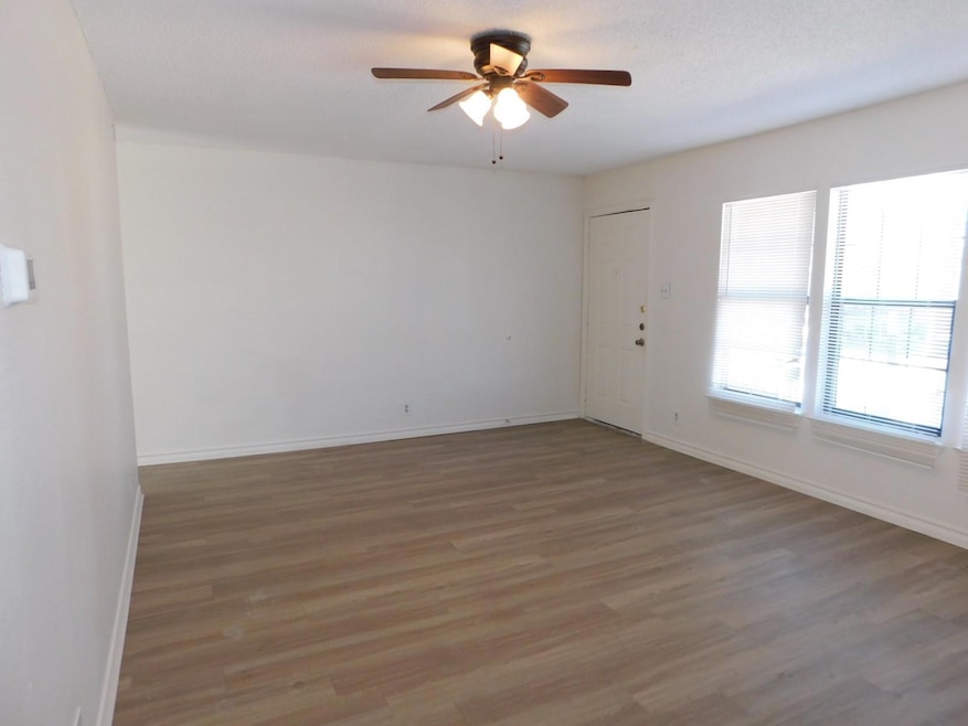 Unfurnished room with baseboards, ceiling fan, an