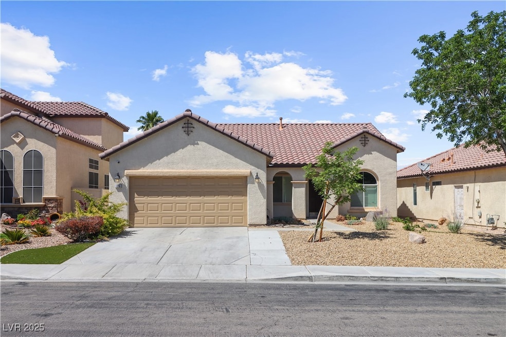 Mediterranean / spanish-style home featuring a gar