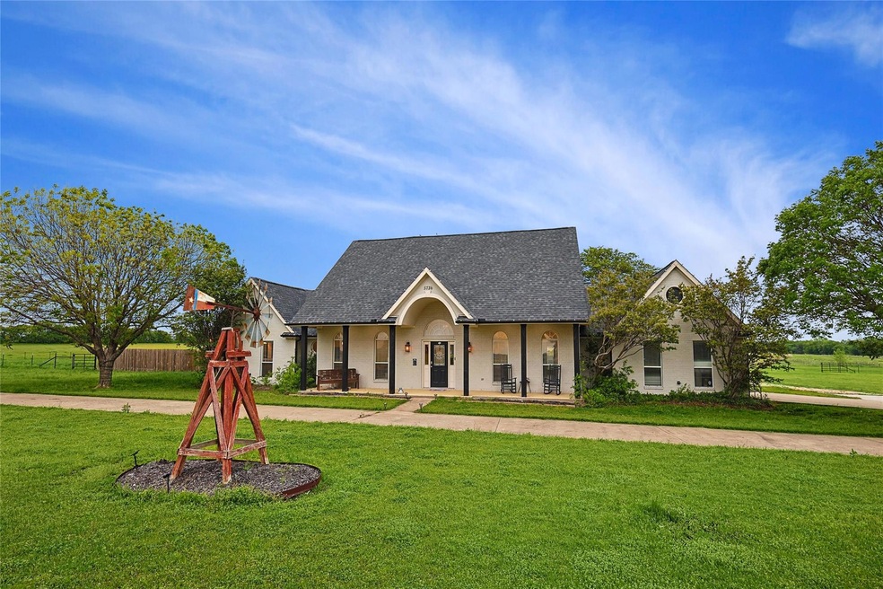 View of front facade featuring a front yard and covered porch
