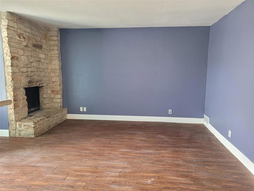 Unfurnished living room featuring baseboards, woo