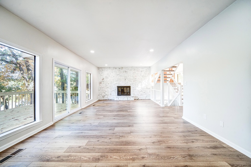 Unfurnished living room with a stone fireplace and