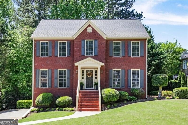 Colonial-style house featuring a front yard