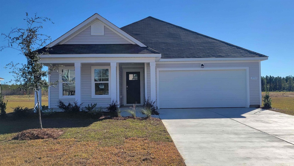 View of front of home with roof with shingles, a front lawn, an attached garage, concrete driveway, and a porch
