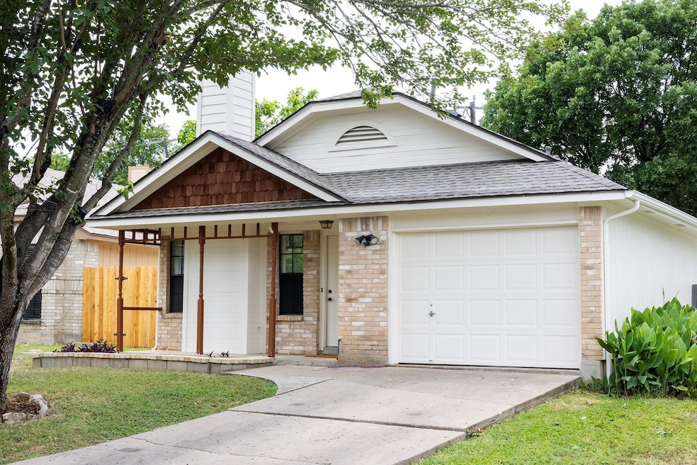 View of front of house featuring driveway, covere