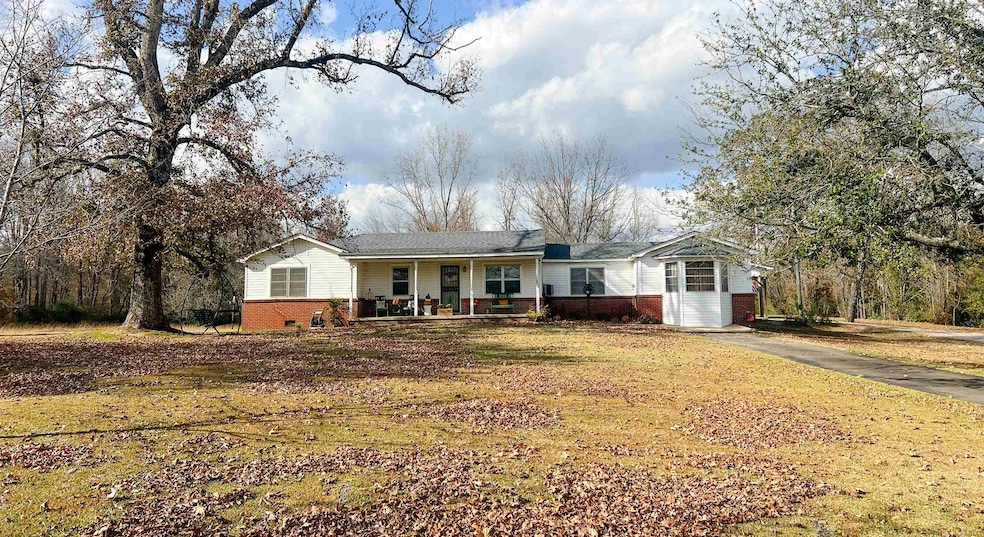 Single story home with covered porch and brick siding.