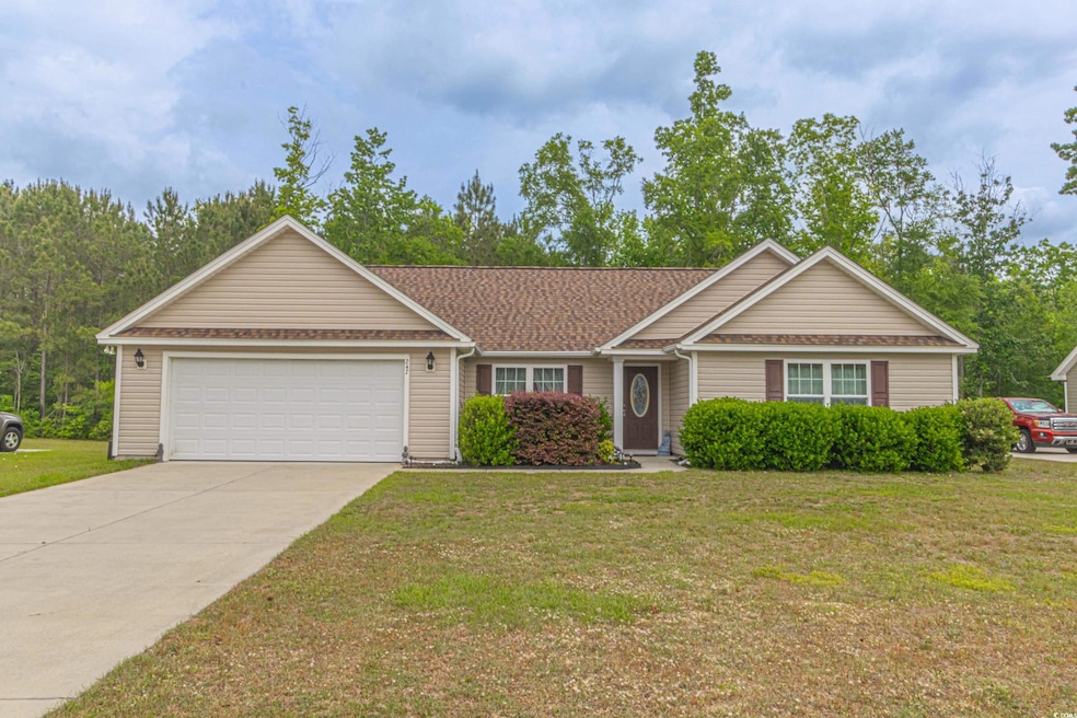 Ranch-style home with concrete driveway, an attached garage, a shingled roof, and a front lawn
