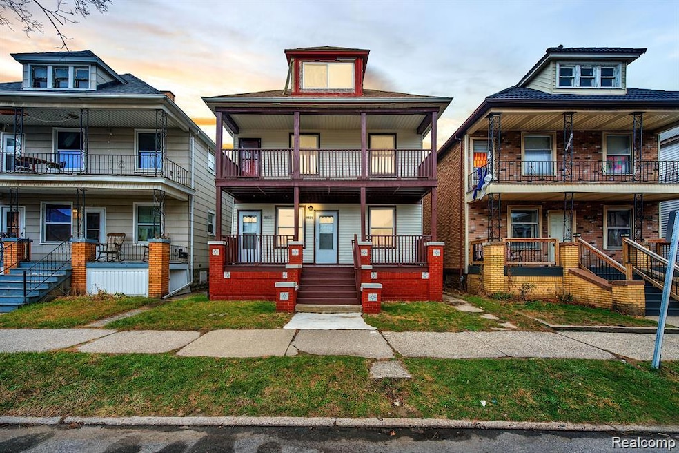 American foursquare style home featuring covered porch and brick siding
