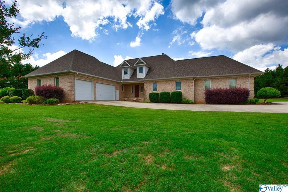 With covered front porch, concrete driveway, and attached garage.