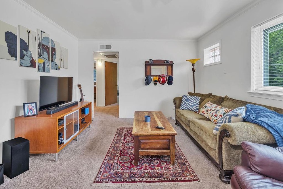 Carpeted living room featuring ornamental molding