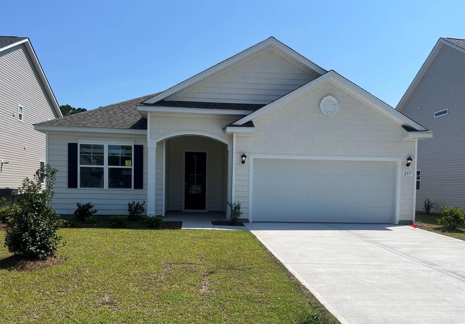 View of front of home with a garage and a front ya