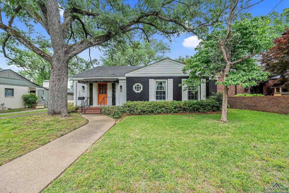 View of front of home with a front lawn, brick siding, and a shingled roof
