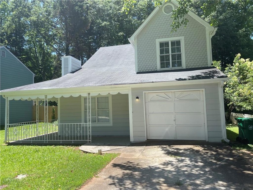 View of front of property featuring a porch, a gar