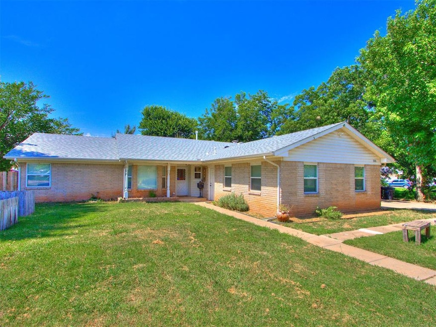 Ranch-style home with brick siding, covered porch, and a shingled roof