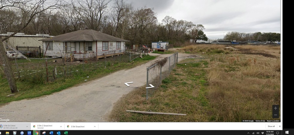 Lot is behind the small white building with the blue door