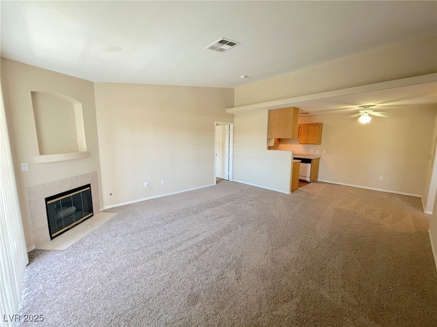 Unfurnished living room featuring ceiling fan, vis