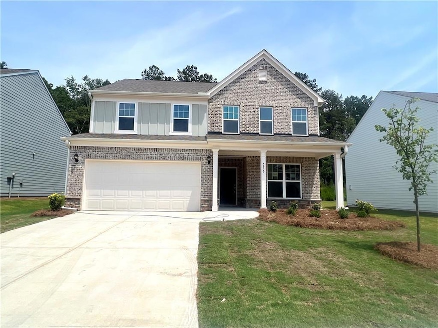 Craftsman inspired home with driveway, an attached garage, board and batten siding, a front lawn, and brick siding