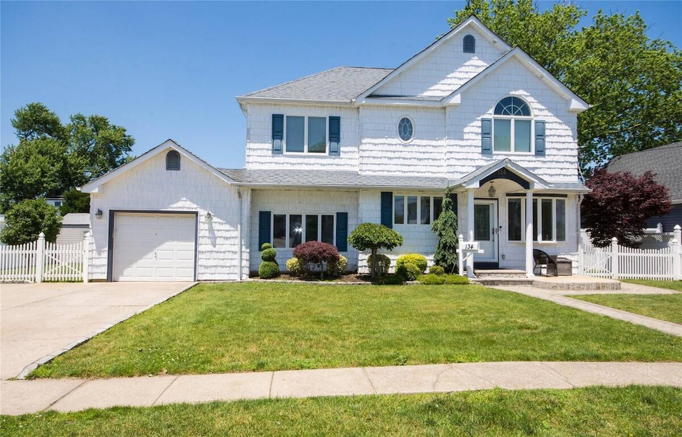 View of front of property with a garage, concrete driveway, and roof with shingles