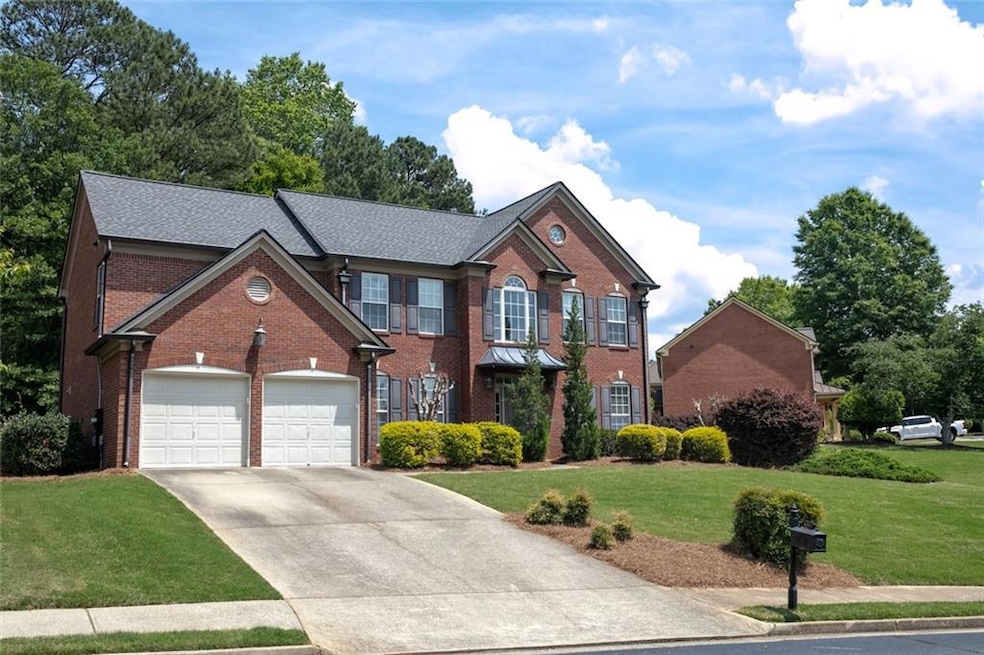Colonial house with brick siding, a garage, drivew