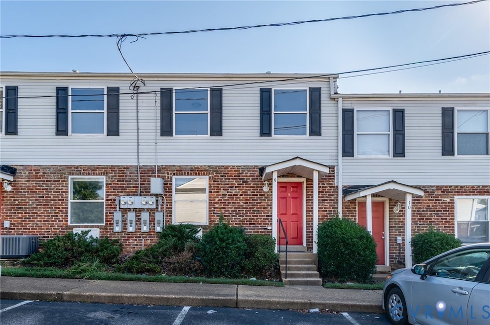 Traditional-style house featuring uncovered parking and brick siding