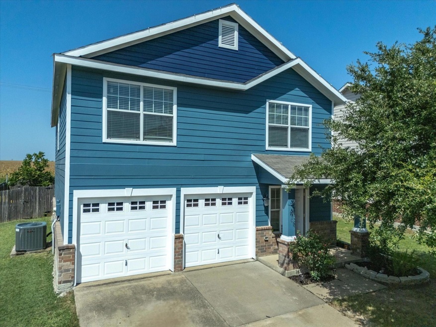 View of front of property featuring central air condition unit and a garage