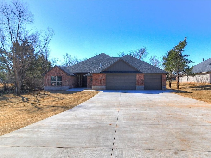 View of front of home with brick siding, a garage,