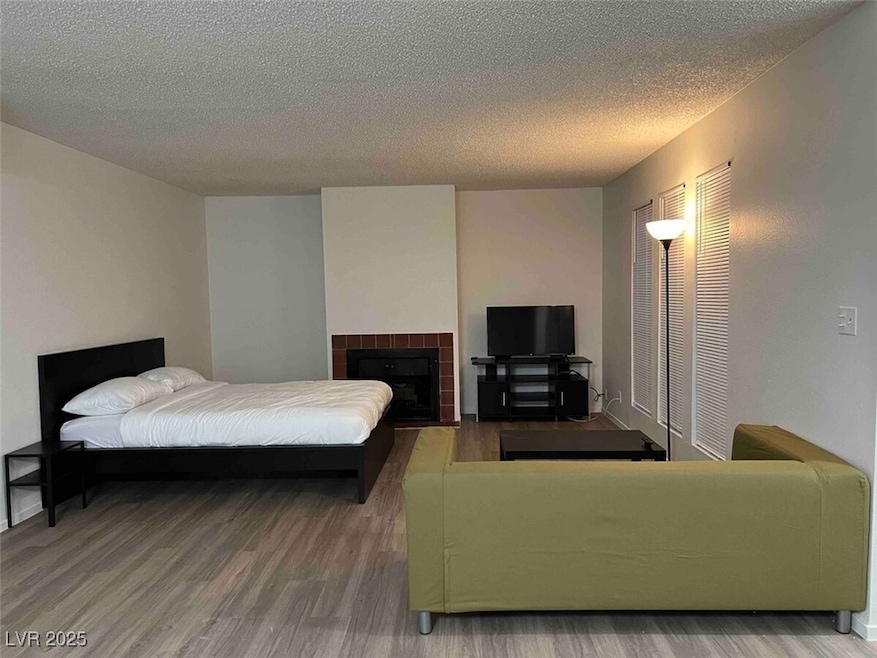 Bedroom featuring wood finished floors, a textured