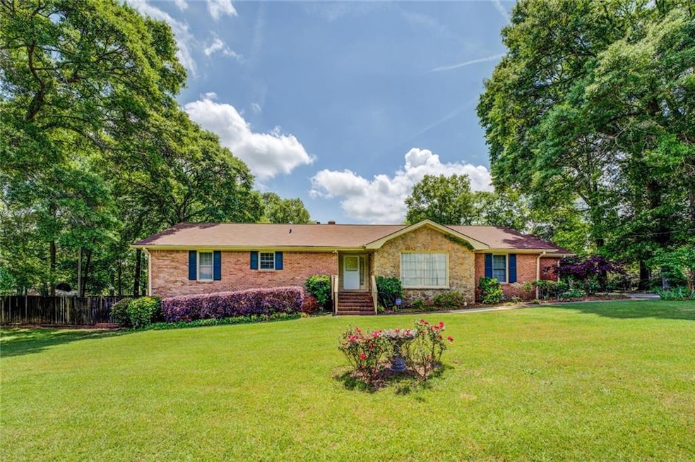 Ranch-style home with fence, brick siding, and a f