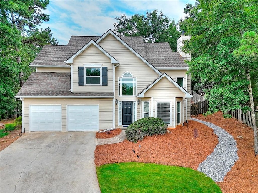 Traditional home featuring a chimney, concrete driveway, and roof with shingles