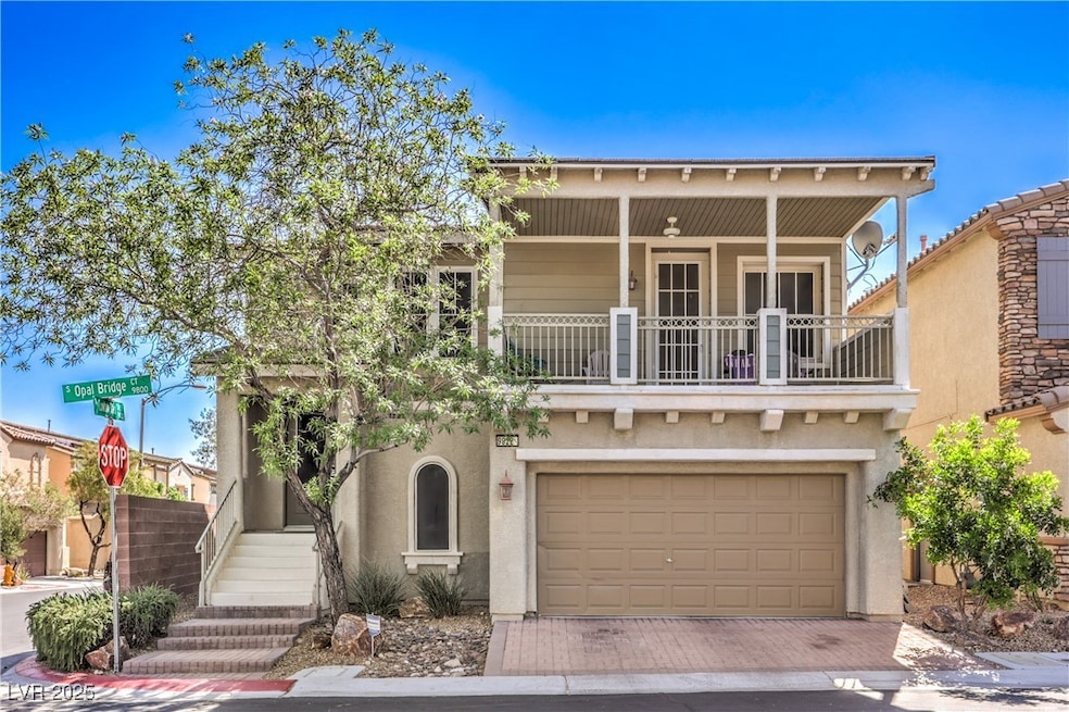 View of front facade with a balcony, a garage, dec
