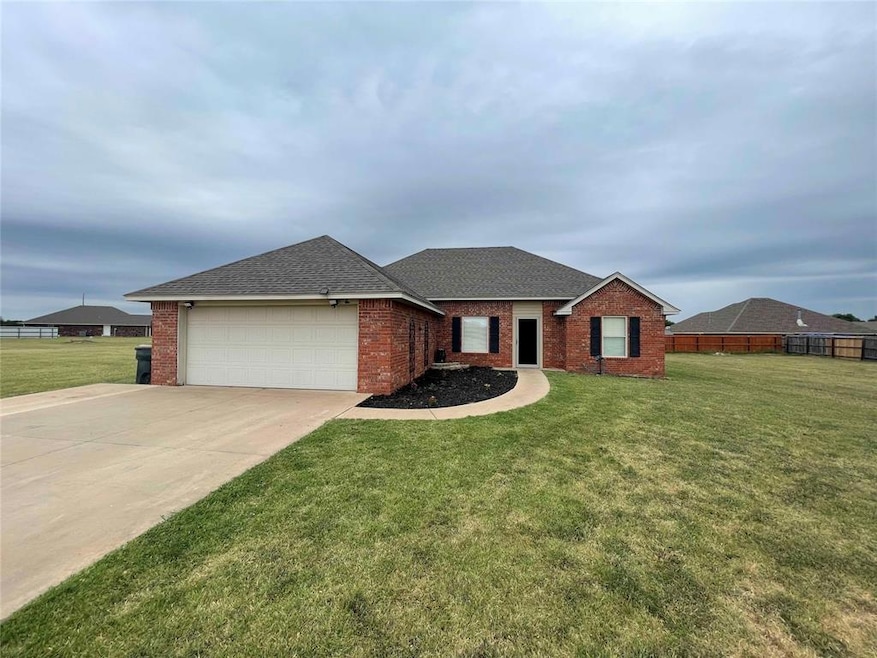 Single story home featuring a front yard and a gar