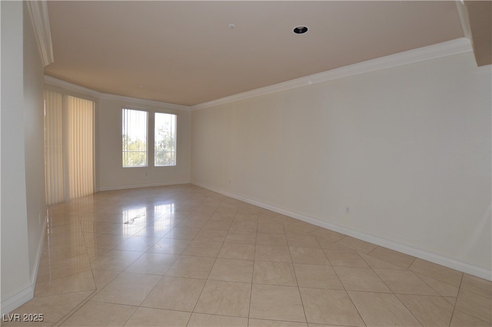Empty room featuring baseboards, light tile patter