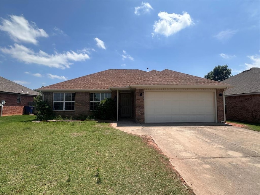 Single story home with concrete driveway, a garage, a front yard, brick siding, and roof with shingles