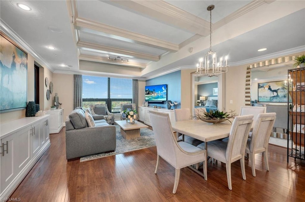 Dining space with beamed ceiling, dark hardwood / wood-style flooring, ornamental molding, and a chandelier