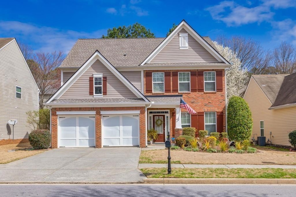 Traditional-style home with brick siding, concrete driveway, a garage, and roof with shingles