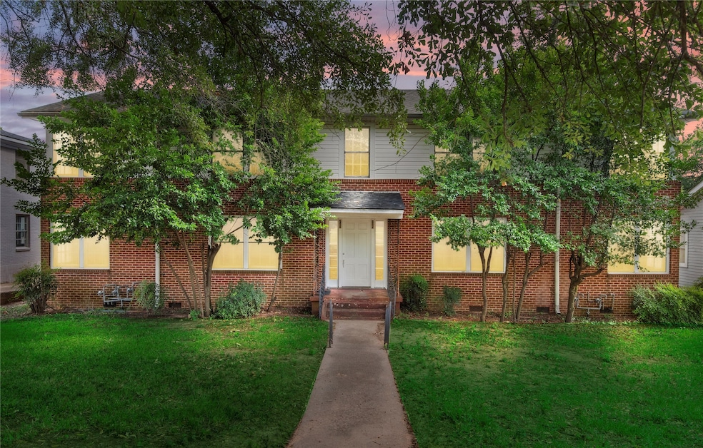 View of front with a front lawn, brick siding, and crawl space