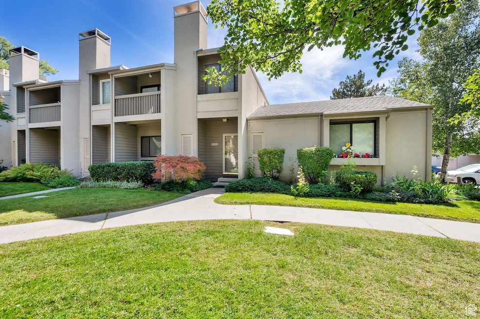 Mid-century modern home with a front yard, a chimney, and stucco siding