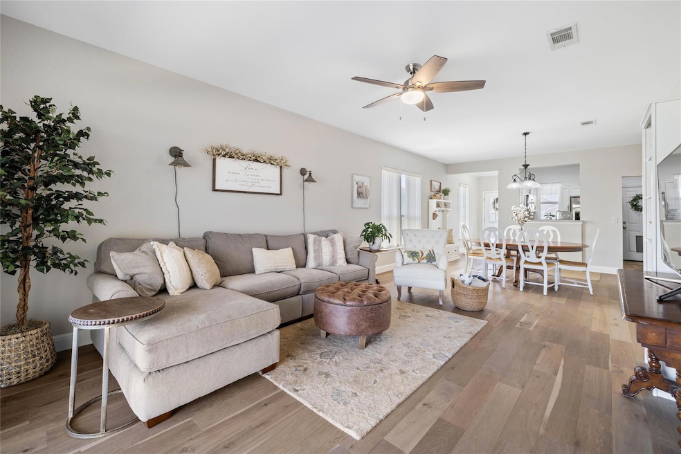 Living area featuring a ceiling fan, wood finishe