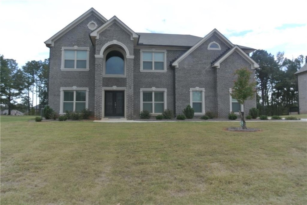 View of front of property featuring 4-sided brick and a front yard