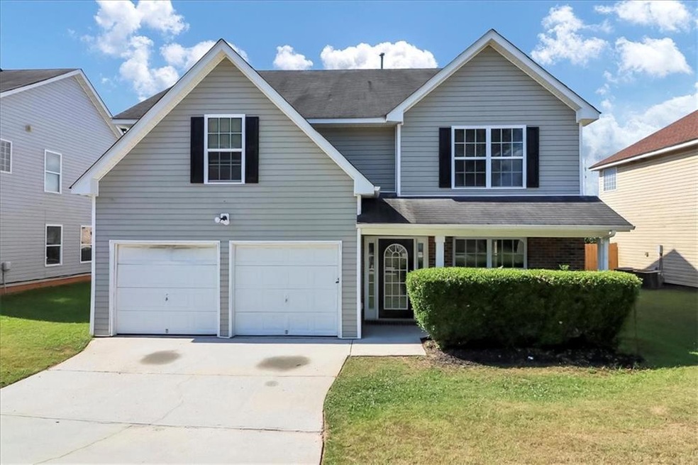 Front facade with a garage and a front yard