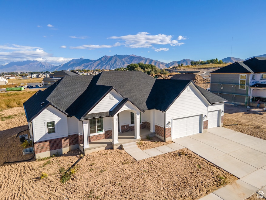 Ranch-style home featuring brick siding, covered porch, a mountain view, and driveway
