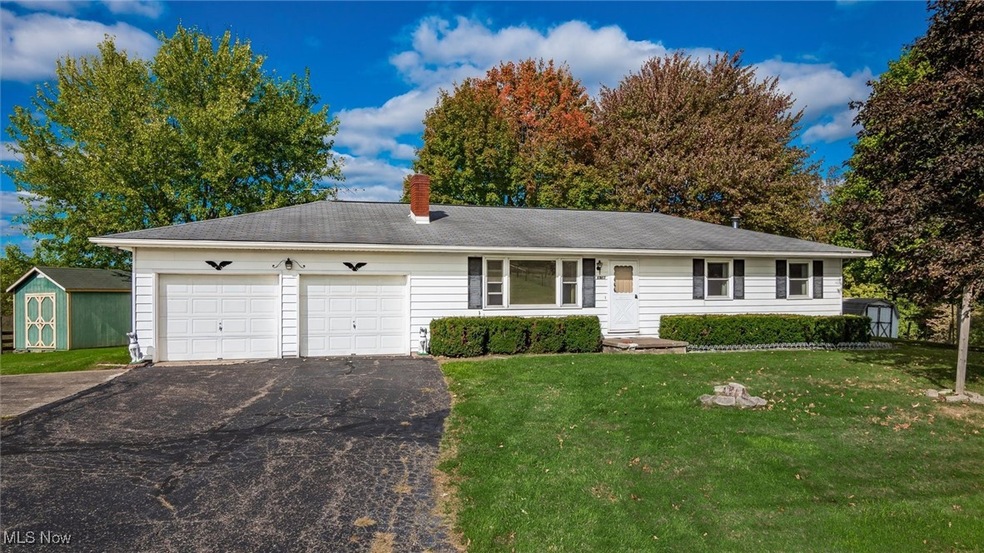 Ranch-style home featuring a storage unit, a front lawn, and a garage