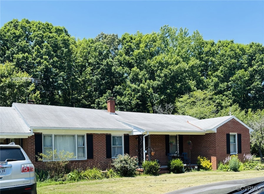 Single story home with brick siding, a front lawn,
